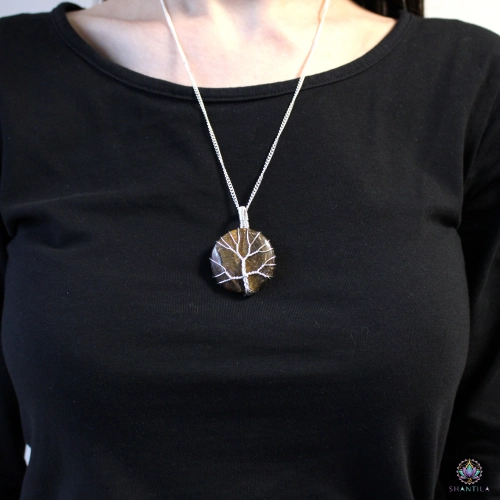 Collier Arbre de Vie Œil de Tigre 2 Collier arbre de vie en œil de tigre porté sur un haut noir, le pendentif tombant sous les clavicules