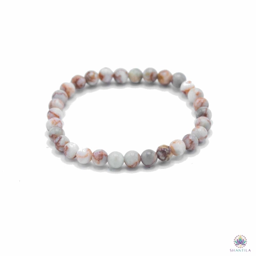 Bracelet Perles Blood Spider Stone — Liens Familiaux 1 Bracelet blood spider stone : perles blanc cassé veinées de rouge, posé à plat sur fond blanc