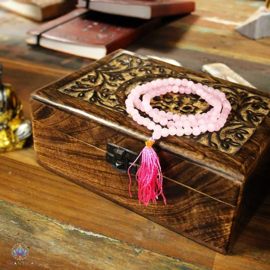 Présentation-sur-socle-bois-du-collier Mala 108 grains en perles de quartz rose naturel avec pompon rose