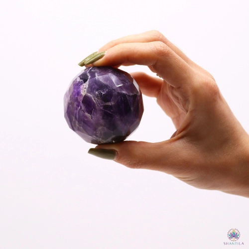 Sphère Améthyste Facettée et son Pied en Bois — 5 cm 3 Sphère en améthyste facettée tenue entre le pouce et l'index, pour juger de ses 5 cm de diamètre