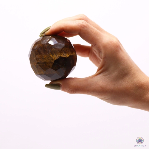 Sphère Œil de Tigre Facettée et son Pied en Bois — 5 cm 3 Sphère en œil de tigre facettée tenue entre le pouce et l'index, pour juger de ses 5 cm de diamètre