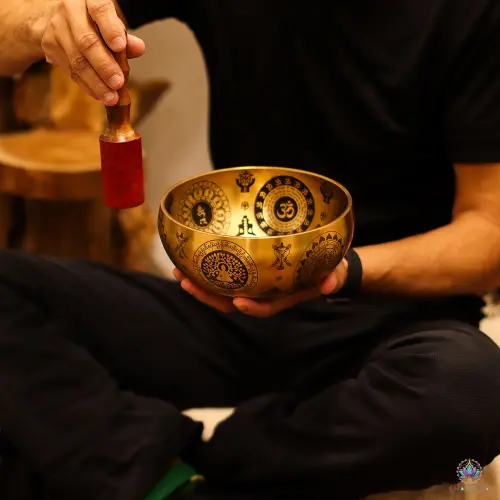 Set de 4 Bols Chantants Laiton Gravés Yogi et Chakras – Emboîtables, Sans Maillet 13 Bol chantant en laiton gravé tenu en séance, maillet gainé rouge levé au-dessus (maillet non inclus)