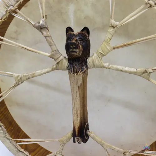 Tambour Chamanique Ours 40 cm – Poignée Sculptée, Accordable, Baguette Incluse 4 Gros plan sur la poignée sculptée en tête d'ours, bois clair aux zones brûlées, laçage ramifié en cuir brut